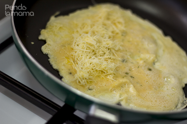 as it hardens in the pan, grate some cheese and and prinkle on one side