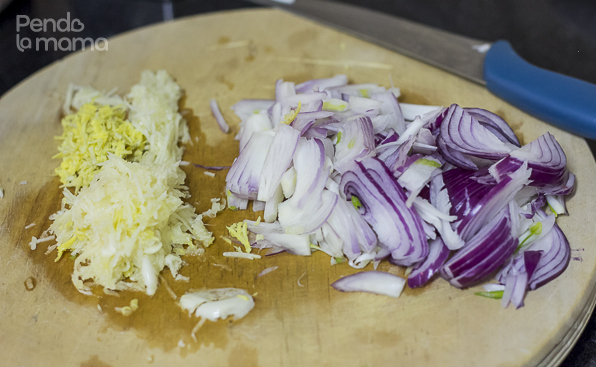 When the meat is no longer bloody, add 2 sliced onions, about an inch piece of grated ginger and 6 large cloves of grated garlic, stir
