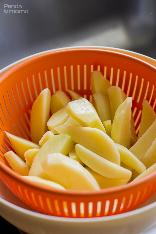 washed potato wedges draining in a colander